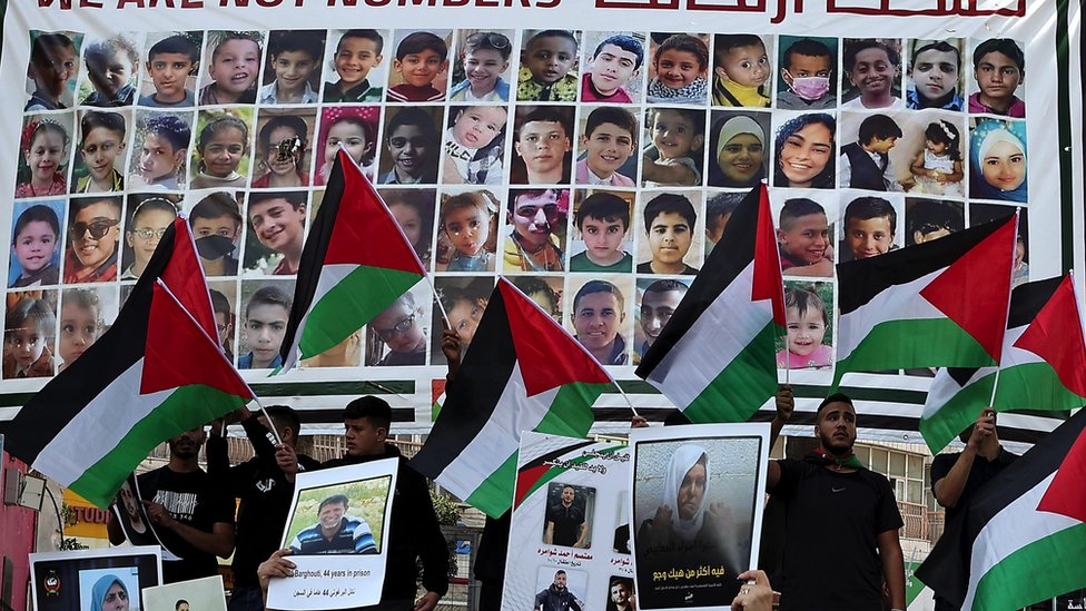 Protesters lift national flags during a rally in Ramallah city in the occupied West Bank, in support of Gaza and of Palestinian prisoners in Israeli jails, on 14 November 2023