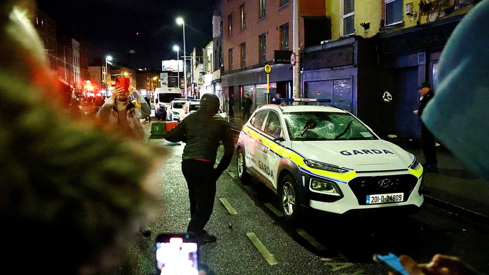 Neredi u Dablinu: Goreli automobili i autobusi 1 Police car being damaged in Dublin