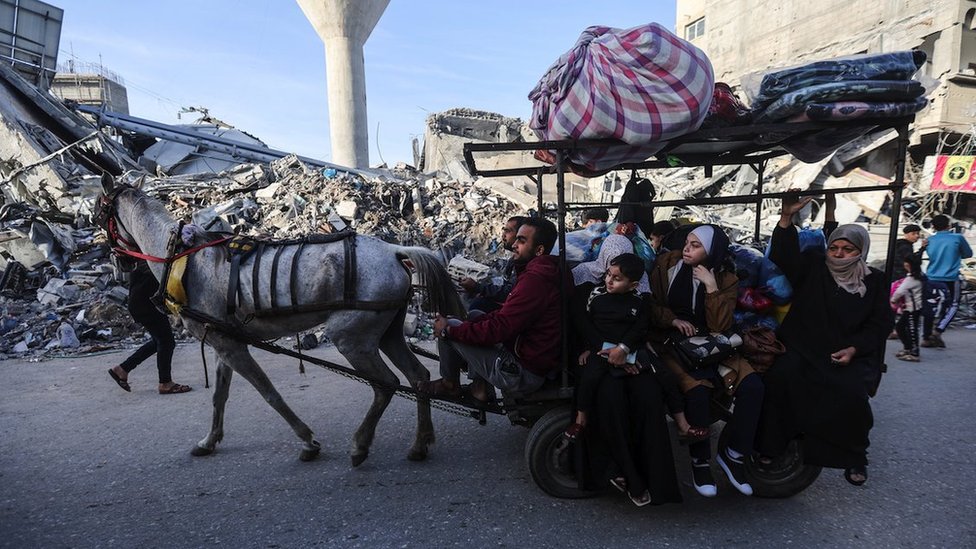 Displaced Palestinians ride on a donkey cart as they make their way home, during a temporary truce between Hamas and Israel, in Khan Younis in the southern Gaza Strip, November 24, 2023.