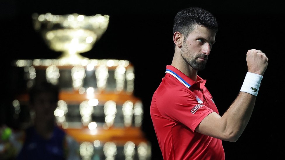 Novak Đoković: Prvi teniser sveta u verbalnom sukobu sa britanskim navijačima posle meča Dejvis kupa 2 Novak Djokovic pumps his fist with the Davis Cup trophy visible in the background