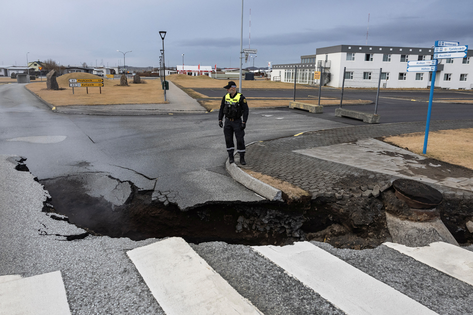 A police officer stands by a crack in a road in the fishing town of Grindavik, which was evacuated due to volcanic activity, in Iceland. November 15, 2023.