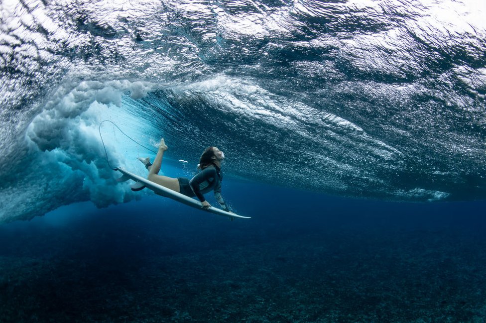 Australian surfer Olivia Ottaway dives under a wave on August 19, 2023 in Teahupo'o, French Polynesia.