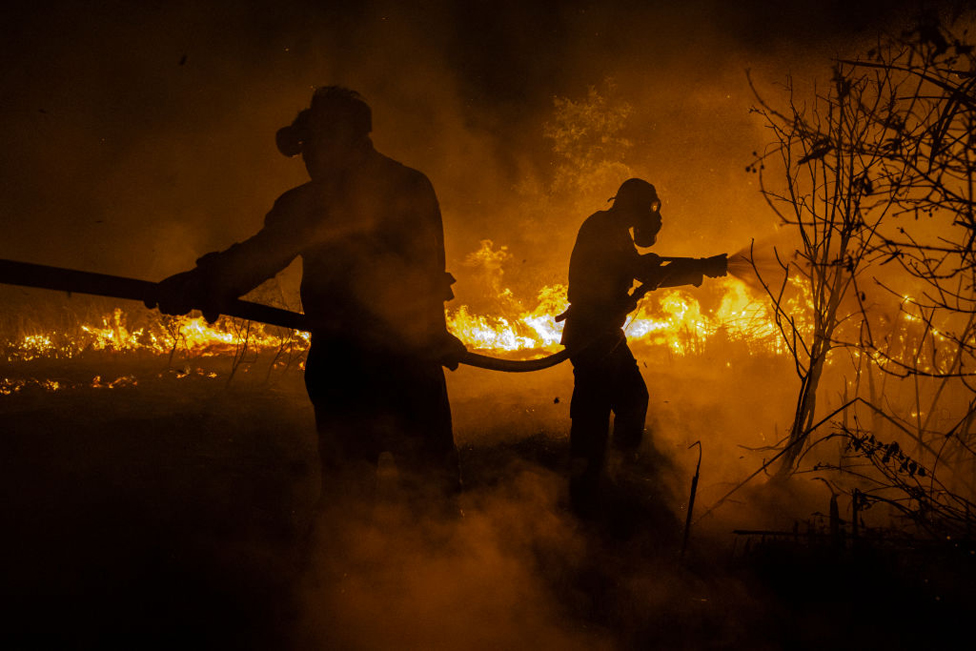 Firefighters attempt to extinguish a wildfire on burned peatland and fields on September 23, 2023 in Ogan Ilir, South Sumatra, Indonesia.
