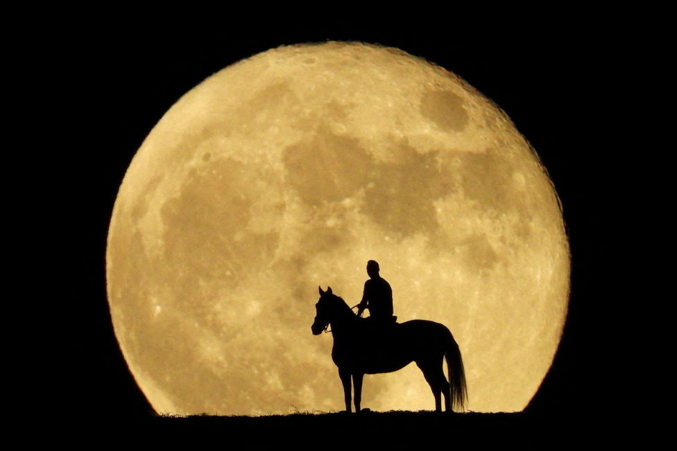 Jonay Ravelo and his horse Nivaria observe the super moon known as the Blue Moon, from a mountain in Mogan, in the south of the island of Gran Canaria, Spain, August 31, 2023.