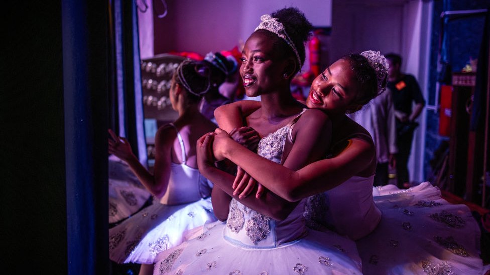Dancers Pauline Okumu (C) and Natalia Como (R) hug at the backstage during the production of the 'Nutcracker' at the Kenya National Theatre in Nairobi on December 2, 2023.