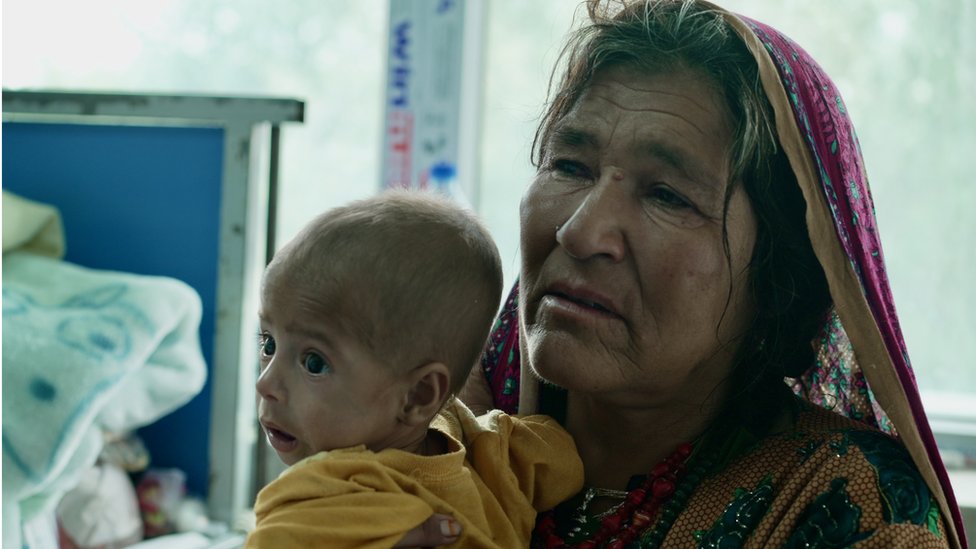 Grandmother Hayat Bibi holds her grandson in her arms