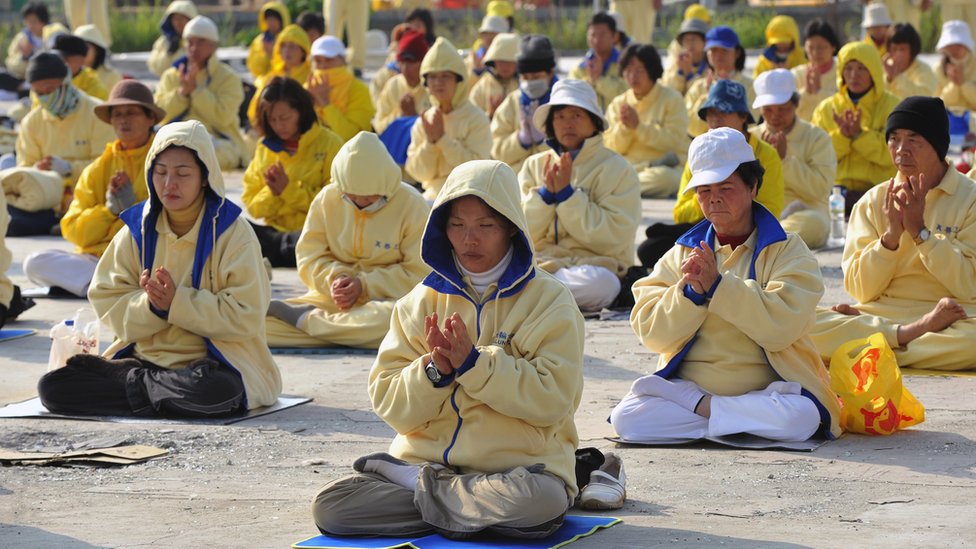 Falun Gong: Zabranjena kineska sekta koja raste van Kine 3 Falun Gong practitioners sit cross-legged at a demonstration in Taiwan