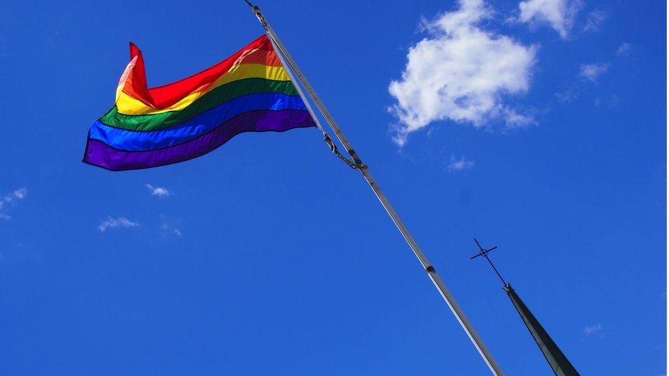 Gay flag and cross belonging to Catholic church