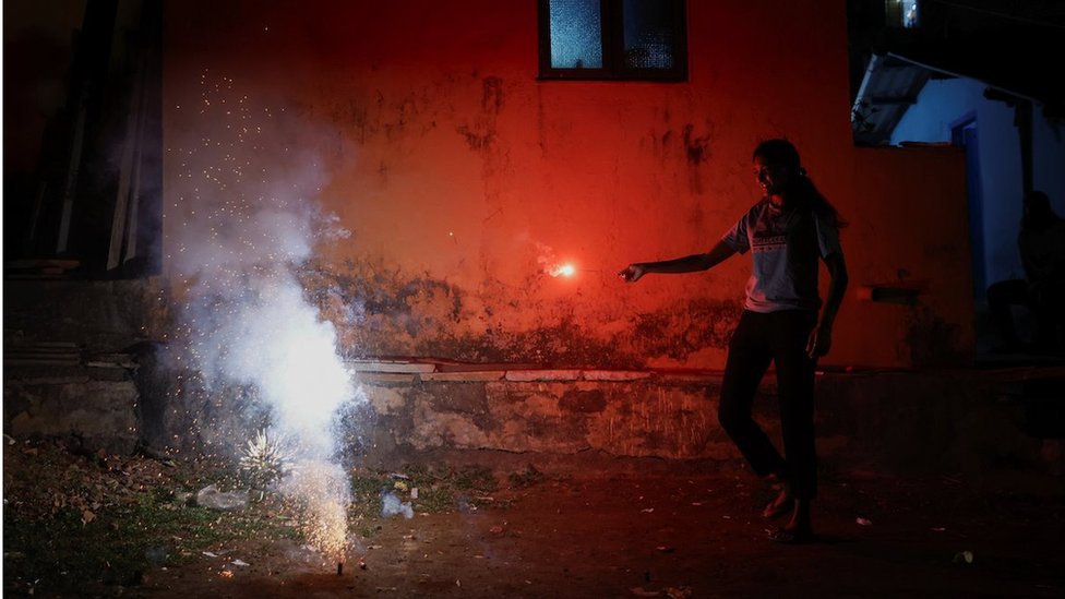 A girl watches firecrackers burn during Diwali, the Hindu festival of lights, in Mumbai, India, November 12, 2023. REUTERS/Francis Macarenhas