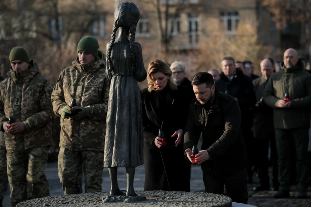 epa10993792 President of Ukraine Volodymyr Zelensky (R) and his wife Olena Zelenska (2-R) place candles at the child statue titled 'Bitter Memory of Childhood' by Petro Drozdowsky at the Holodomor Genocide complex of the National Museum in Kyiv, Ukraine, 25 November 2023. The victims of the Holodomor, Ukrainian for 'Death by starvation,' are traditionally commemorated in Ukraine on the last Saturday of November. The Holodomor, or the Great Famine, in the former Soviet era Ukraine in 1932-1933 caused millions of Ukrainian lives. 