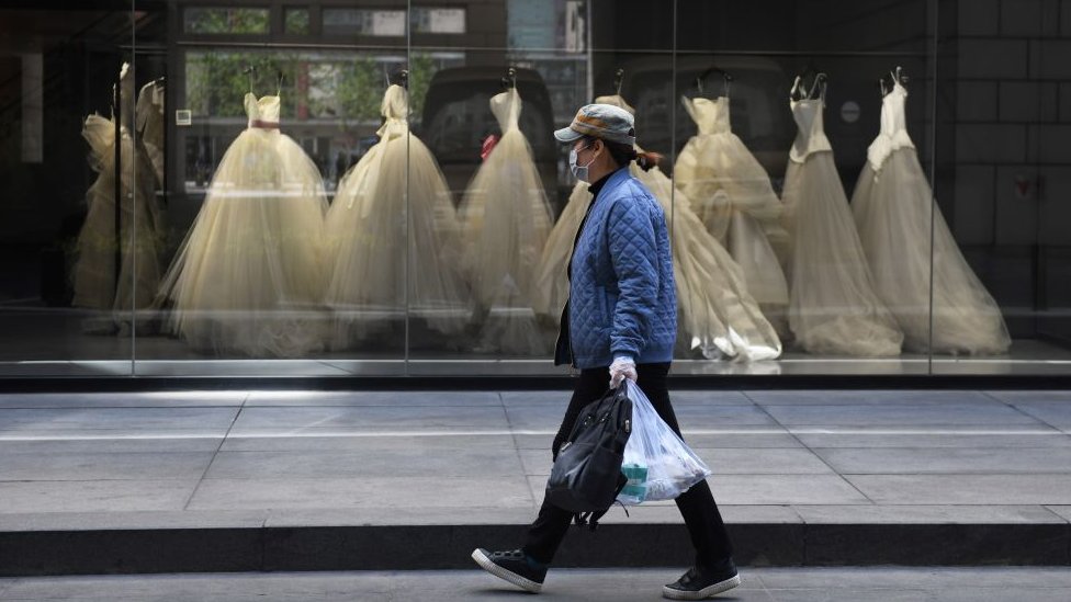 Kina: Kako Komunistička partija učestvuje u provodadžisanju 2 A woman walks past wedding dresses displayed in a Vera Wang bridal store in Beijing on April 22, 2020.