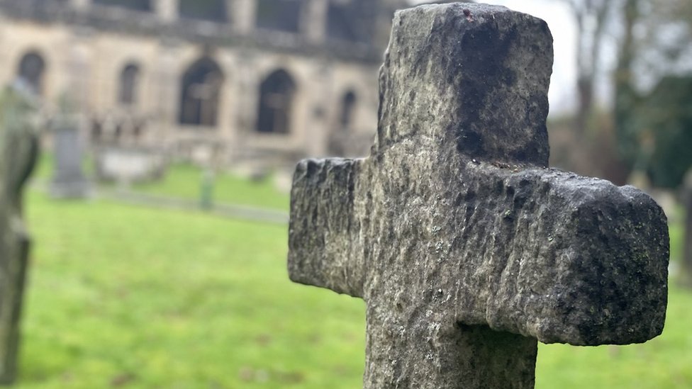 Istorija: Otkrivena zlodela srednjevekovnog kaluđera 'gangstera' u Engleskoj 6 A stone cross against the blurred background of Malmesbury Abbey