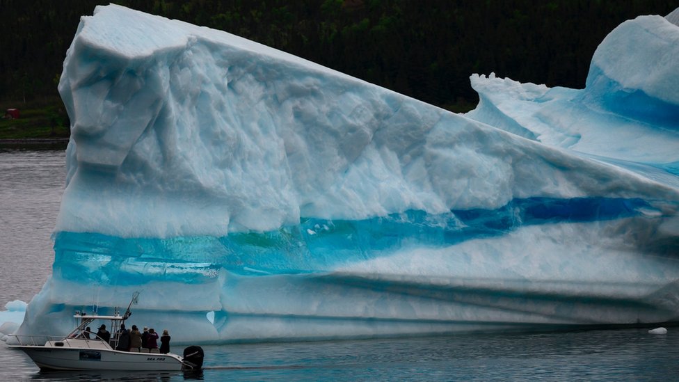 Tour guide and former fisherman Barry Strickland steers his boat next to an iceberg at the seashore of King's Point on July 3, 2019 in Newfoundland, Canada.