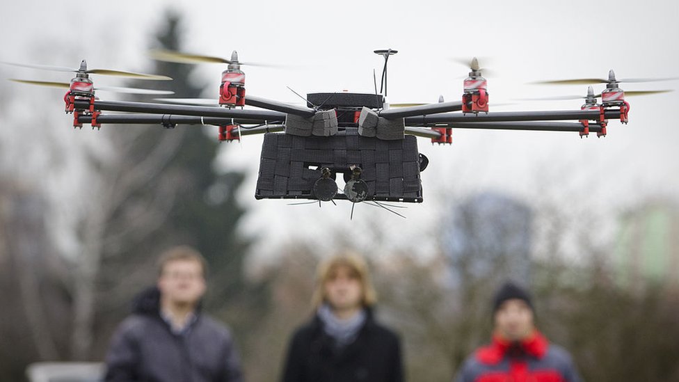 Tehničari posmatraju Amazonov Oktokopter dron
