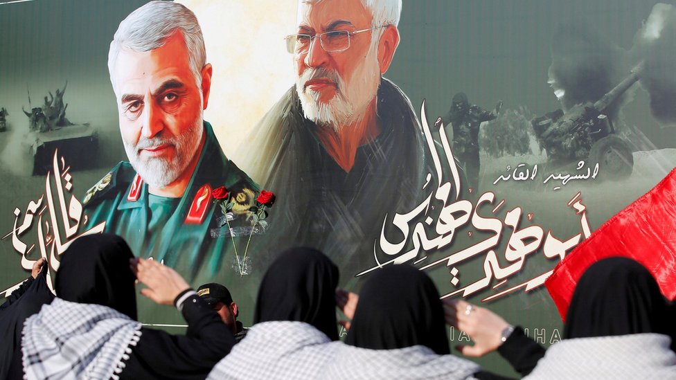 Iran: Više od 100 mrtvih u dve eksplozije blizu grobnice generala Kasema Sulejmanija 4 Iraqi women salute a poster of Qasem Soleimani (L) and Abu Mahdi al-Muhandis near where the two men were killed in a US drone strike in Baghdad(29 June 2020)