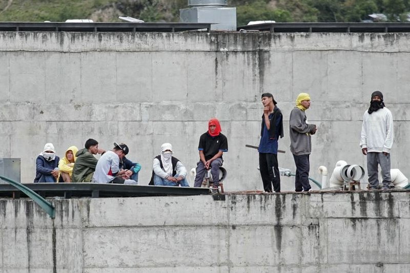 Ekvador i kriminal: Tri ključne tačke koje objašnjavaju „unutrašnji oružani sukob“ 2 Prison inmates stand guard on a roof