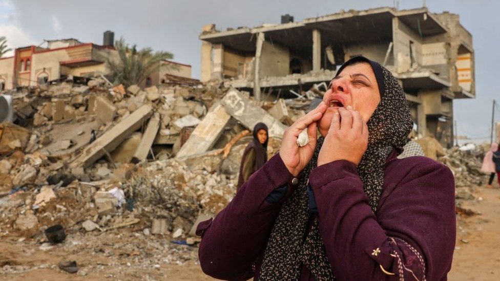 A Palestinian woman reacts as people inspect the damage after Israeli strikes on Rafah, on the southern Gaza Strip, in November 2023