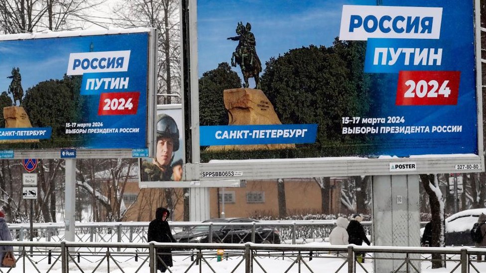 Njerëzit kalojnë pranë një billbordi që shpall zgjedhjet presidenciale të 2024 nën sloganin "Rusia, Putin 2024"