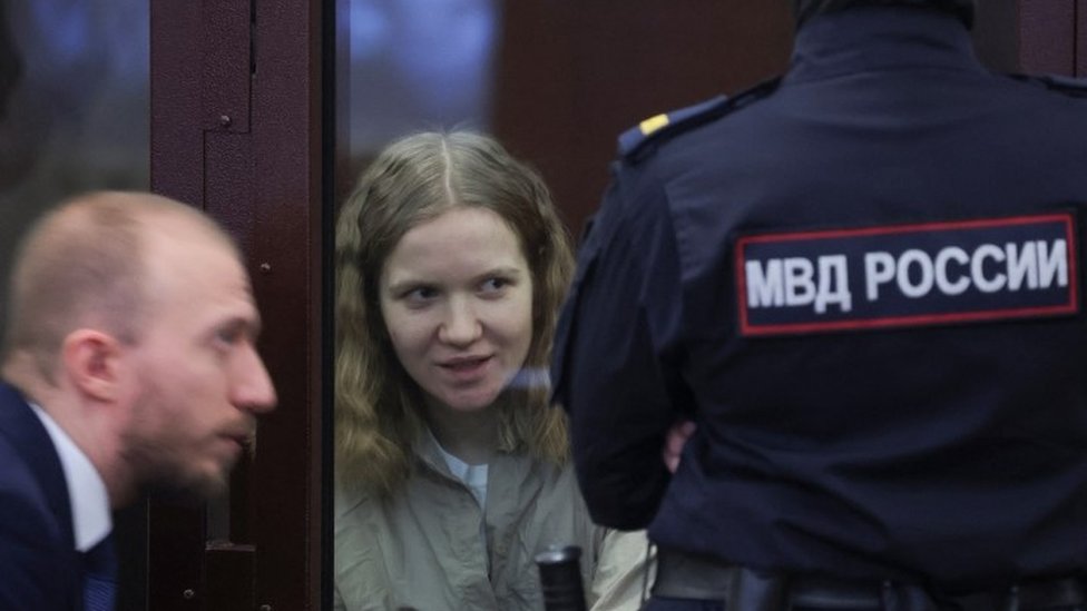 Rusija i Ukrajina: Ruskinja Darja Trepova osuđena na 27 godina zatvora zbog zbog dizanja u vazduh kafića u Sankt Peterburgu 1 Darya Trepova speaking in court to her lawyer as an interior ministry official looks on - 22 January