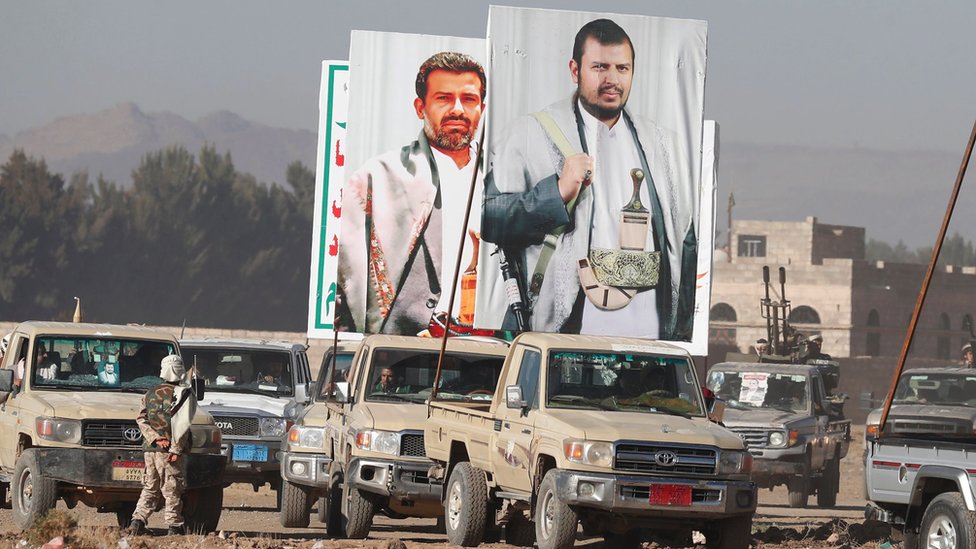 A pick up truck carries a big banner depicting the top leader of the Houthis, Abdul-Malik Al-Houthi (R) during an anti-US and anti-Israel protest, on the outskirts of Sanaa, Yemen, on 25 January 2024
