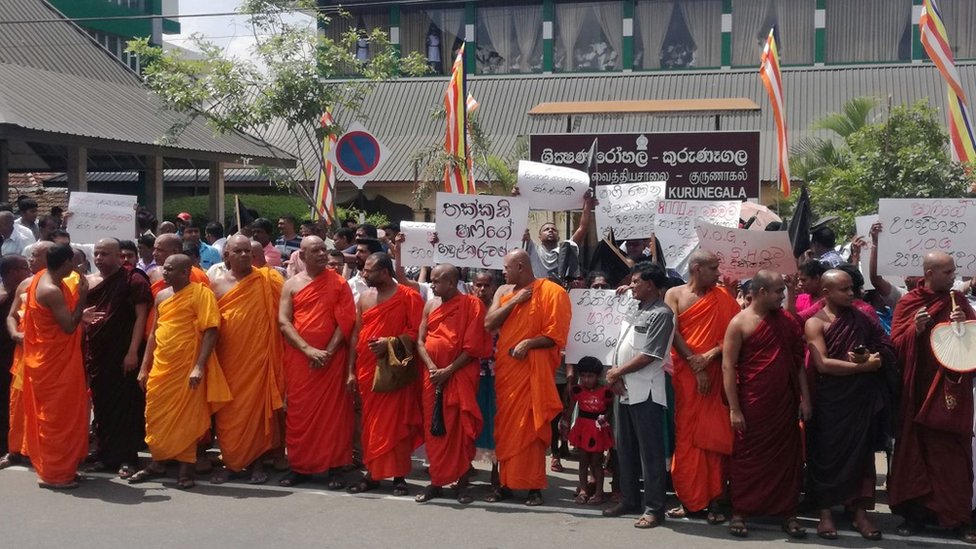 Buddhist monks protest outside the Kurunegala Teaching Hospital in Kurunegala, following the arrest of Muslim doctor Mohamed Shafi (Photo by STR / AFP) (Photo credit should read STR/AFP via Getty Images)