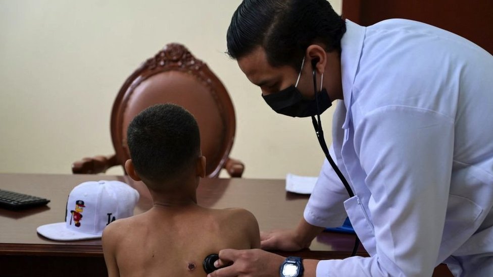 A doctor examines a child with a bullet wound at an Ecuadorian police station