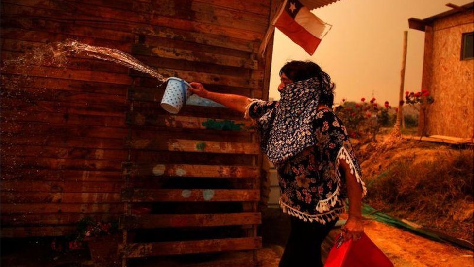 A woman tries to put out a fire in the Quilpe commune, in Valparaíso.