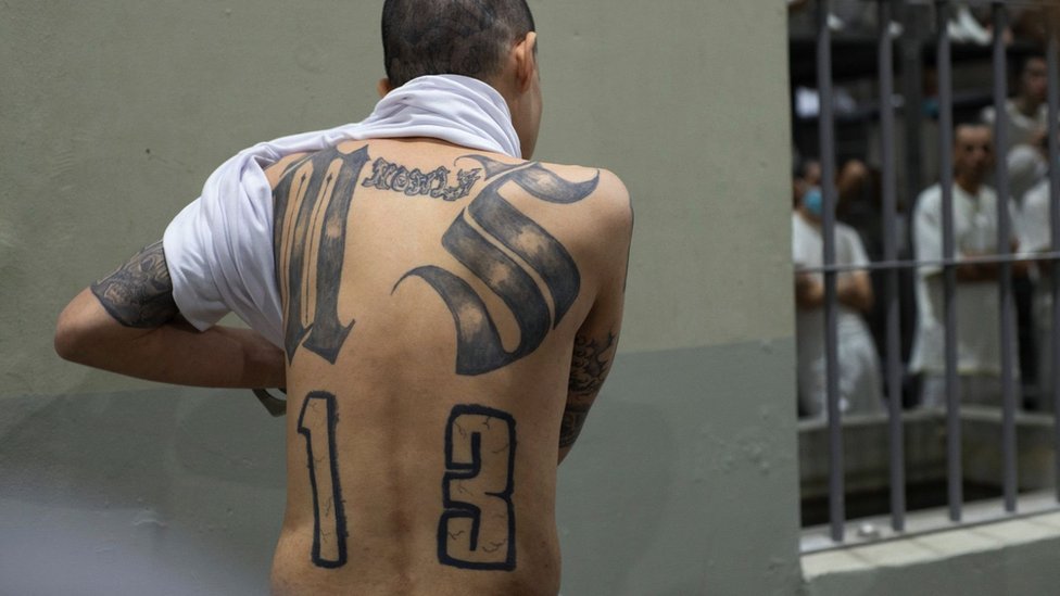 A prisoner shows his back tattooed with symbols of the Mara Salvatrucha gang