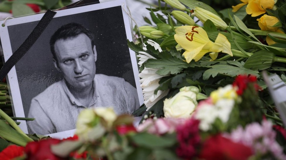 A portrait of deceased Alexei Navalny is positioned between flowers during a rally in Berlin
