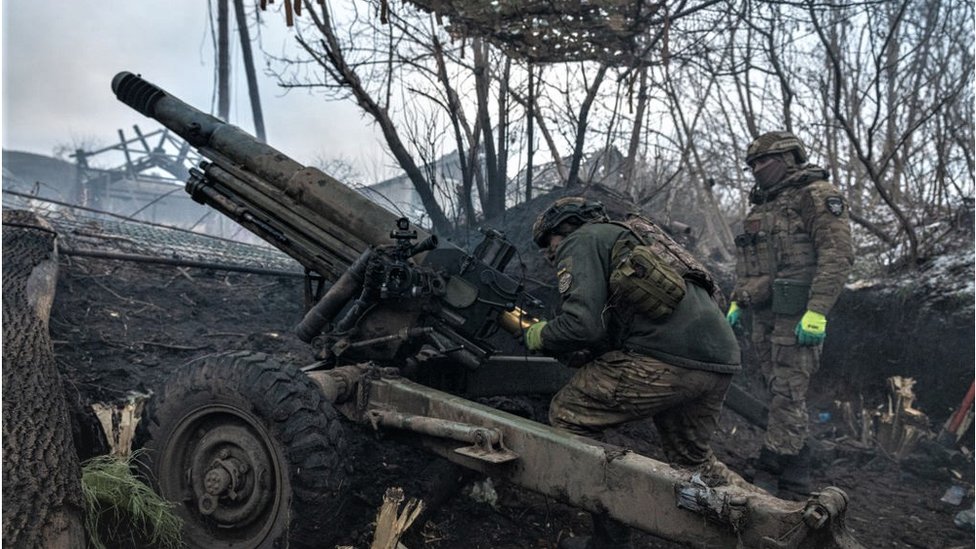 Ukrainian soldiers reload an artillery unit on the front line