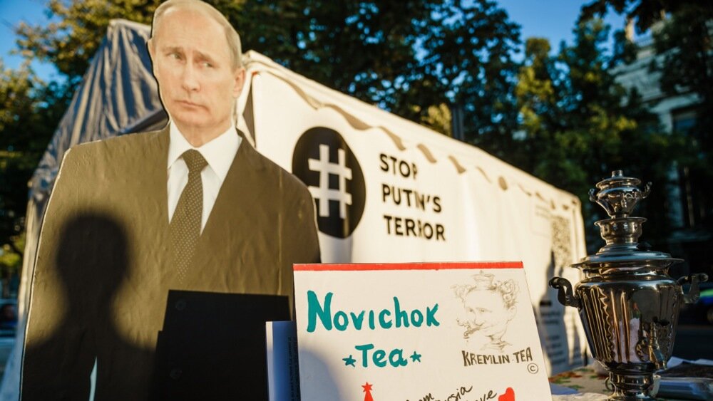 epaselect epa08679342 A staged protest in front of the Russian embassy shows a picture of Russian President Vladimir Putin (C), Russian opposition activist Alexei Navalny (L) and a Russian teapot samovar with a note reading 'Novichok tea', 'Kremlin tea' and 'from Russia with love', in Berlin, Germany, 16 September 2020. Navalny is receiving treatment at the Charite hospital in Berlin since 22 August 2020 after being poisoned with a nerve agent from the Novichok group. 