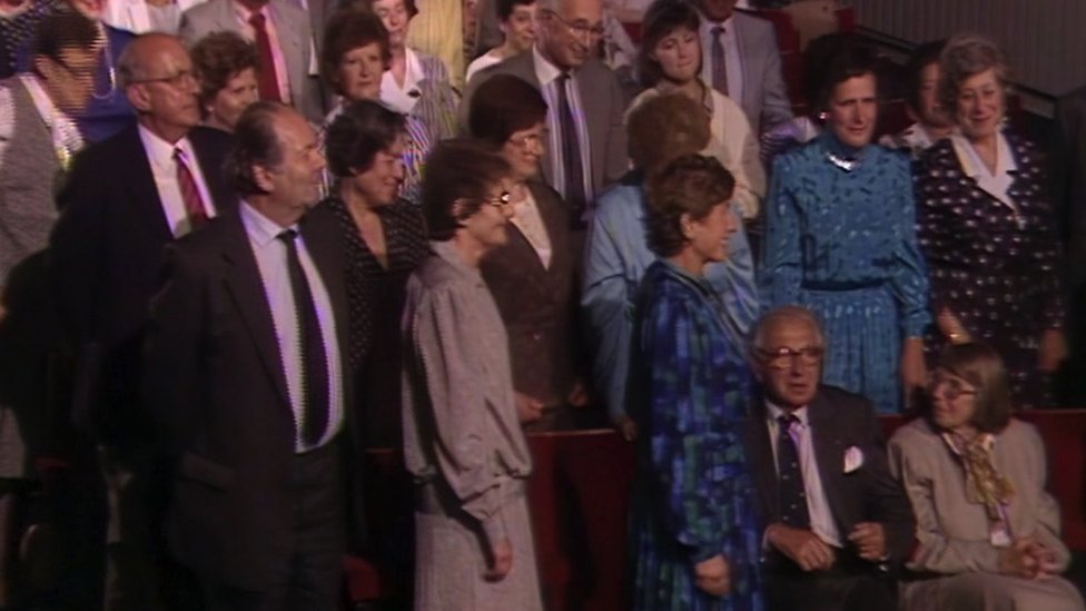 Renata Kolins stoji iza i udesno od ser Nikolasa Vintona i njegove supruge Grete (sedi) u publici za To je život 1988. godine
