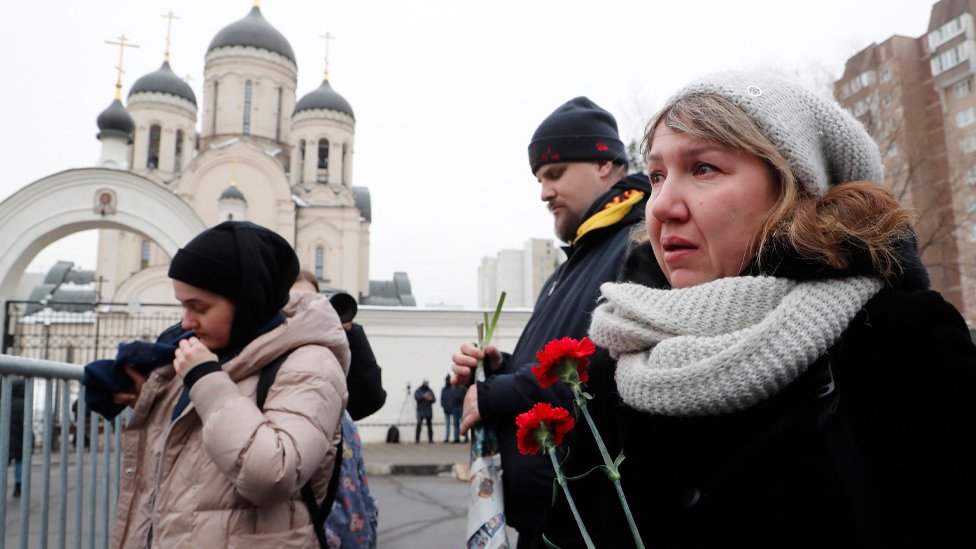 People react outside the Church of the Icon of the Mother of God, ahead of the upcoming funeral of late Russian opposition leader Alexei Navalny, in Moscow
