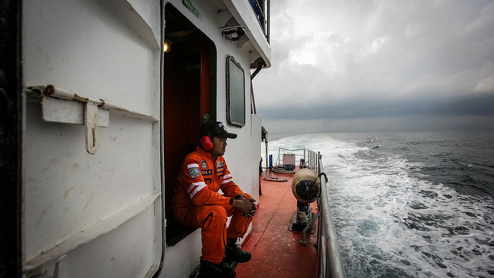 Indonesian national search and rescue agency personnel watch over high seas during a search operation for missing Malaysia Airlines flight MH370 in the Andaman Sea on March 15, 2014.