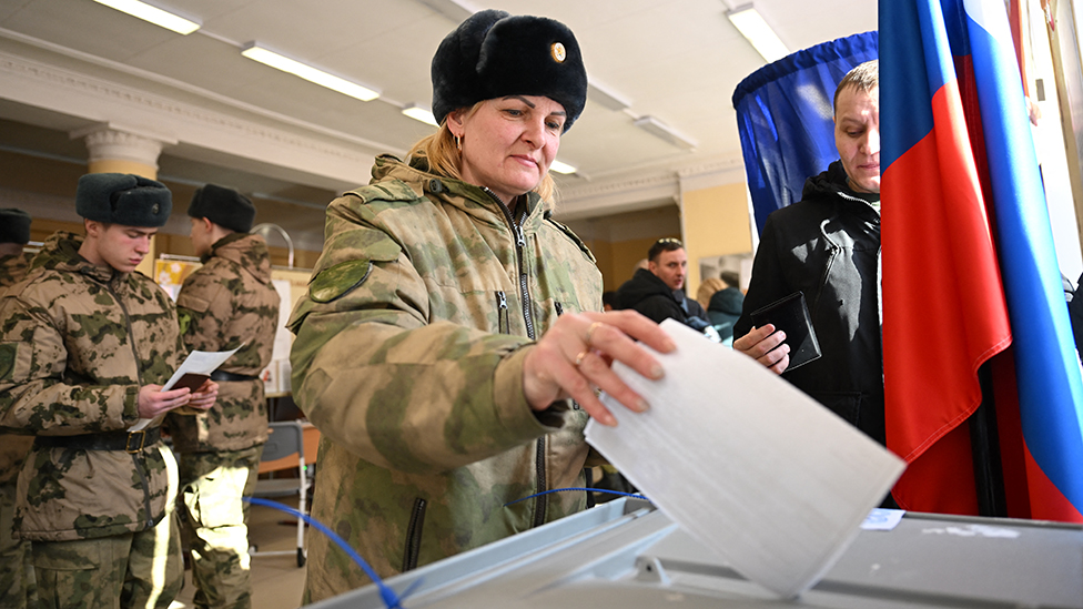 Predsednički izbori u Rusiji 2024: Putin osvojio peti mandat i poručio Zapadu „ovo je demokratija" 8 A service member casts her ballot in Russia's presidential election in Moscow on March 15, 2024