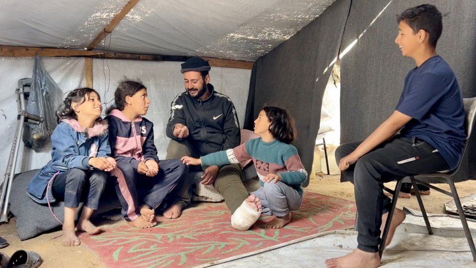 Alma with her uncle Sami and her cousins at their tent in Rafah, in the southern Gaza Strip