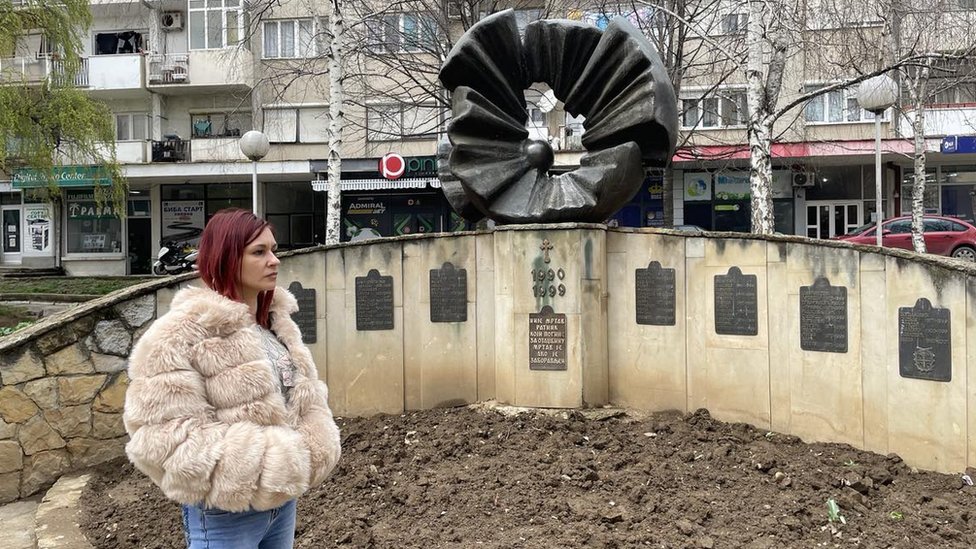 Ivana Đurković ispred spomenika u centru Prokuplja posvećenom stradalim borcima iz ratova devedesetih
