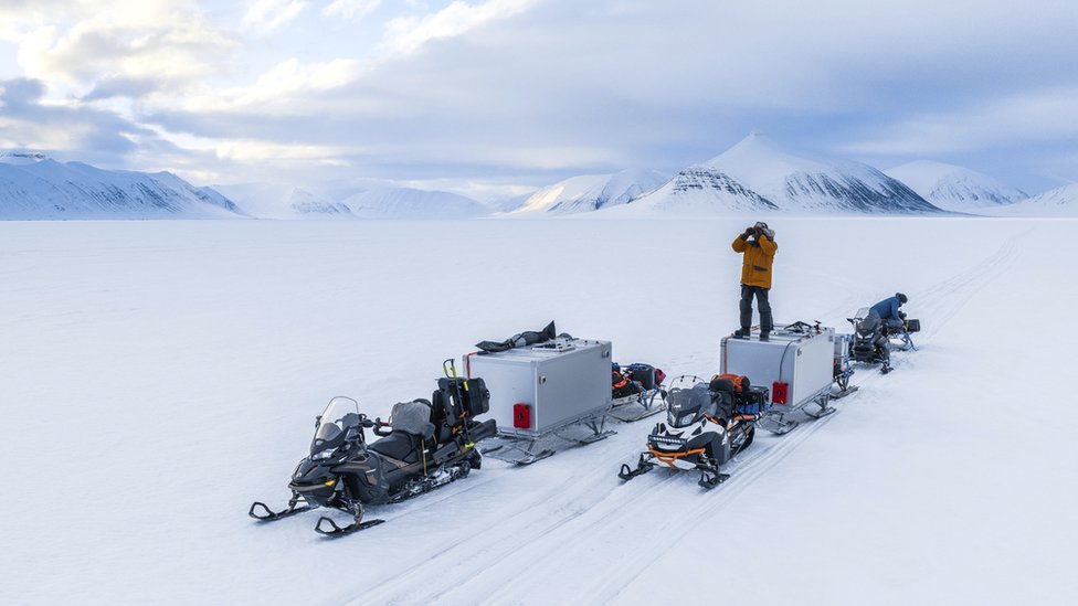 Životinje: Sisari se bore za život u novoj seriji Dejvida Atenboroa 3 BBC crew member searches the horizon for polar bears in Svalbard, Norway. Standing on a two-person 'sleeping pod' built specially - to allow the film crew to remain with the polar bears around the clock.