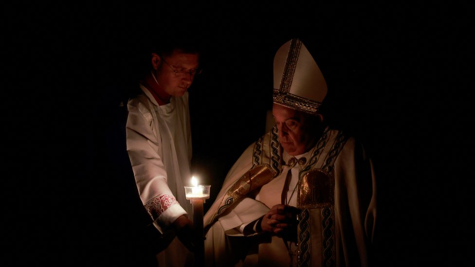 The Pope looks at a candle during the Easter Vigil