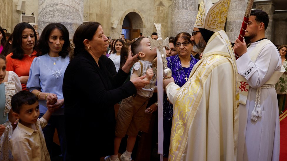 „Mir se ne sklapa oružjem", poruka papa u Uskršnjoj poslanici 11 A worshipper kisses a cross during an Easter vigil service at the Grand Immaculate Church in Al-Hamdaniya, Iraq
