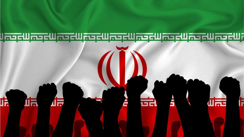 Silhouette of raised arms and clenched fists on the background of the flag of Iran