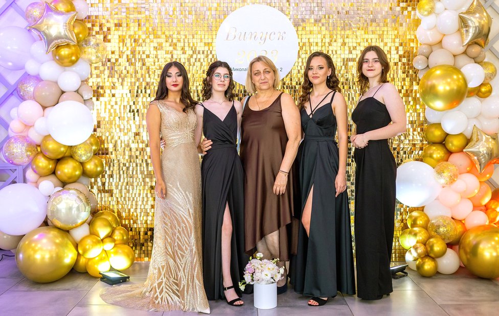 (From left to right) Sofiia, Aliesia, their former teacher Svetlana, Iryna and Yuliia in Mykolaiv, celebrating their prom in July 2023