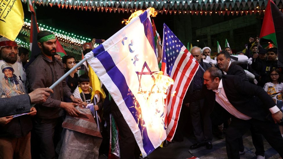 Protesters burn the Israeli and US flags at a anti-Israel demonstration in Tehran, Iran (1 April 2024)