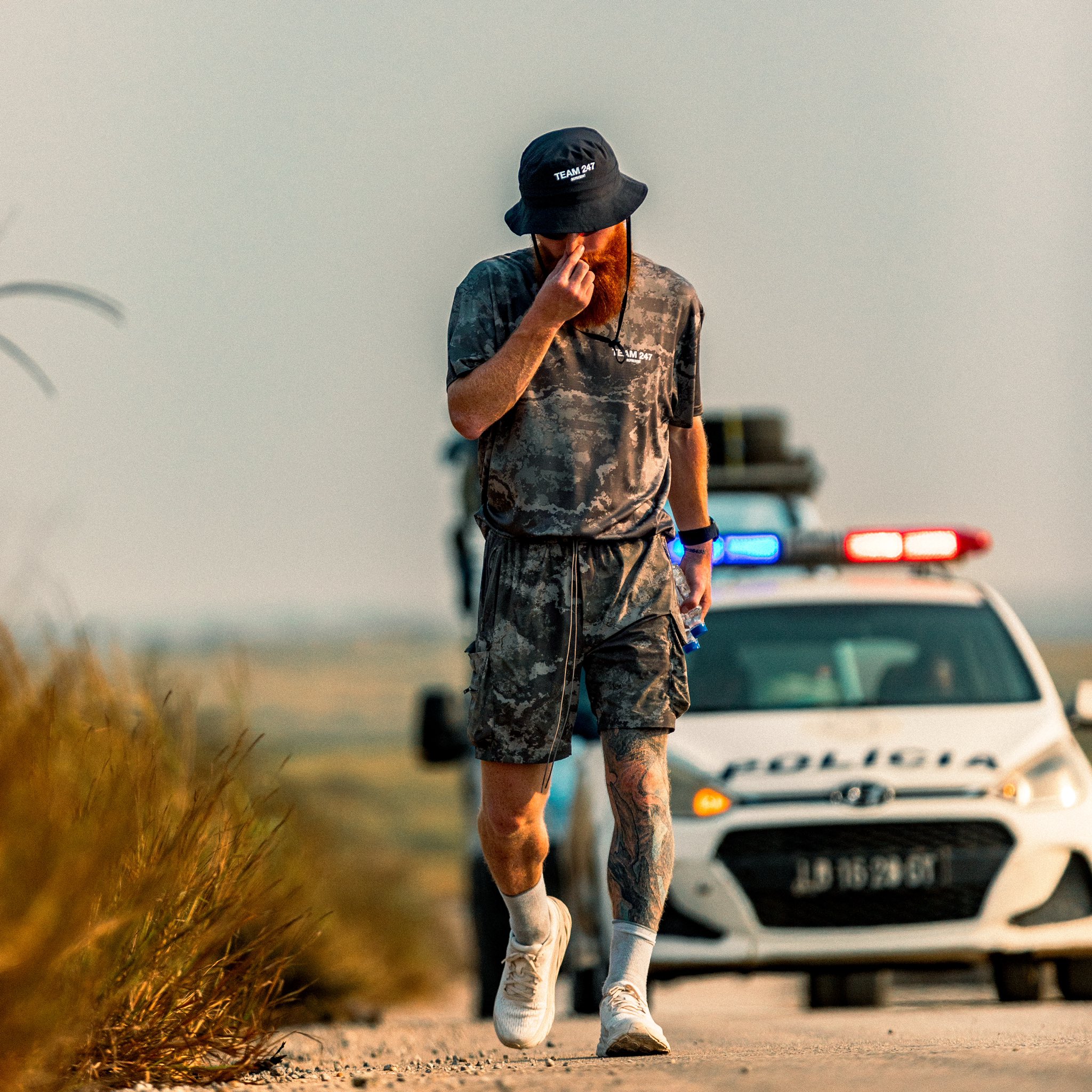 Russell Cook running alongside police car
