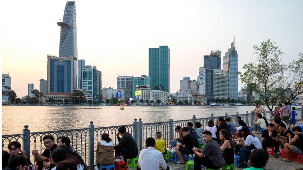 People relax on the bank of Saigon River in Ho Chi Minh City, Vietnam, on Sunday, February 25, 2024.