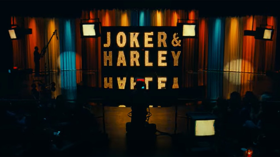Shot from Joker 2 showing an illuminated sign saying "Joker & Harley"