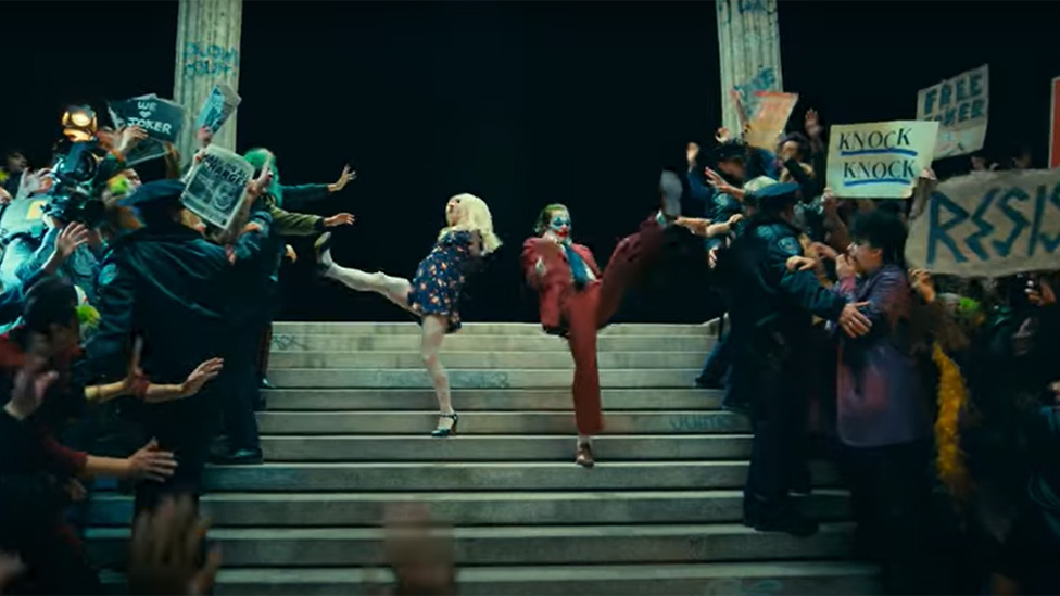 Lady Gaga and Joaquin Phoenix dancing on courtroom steps in Joker 2