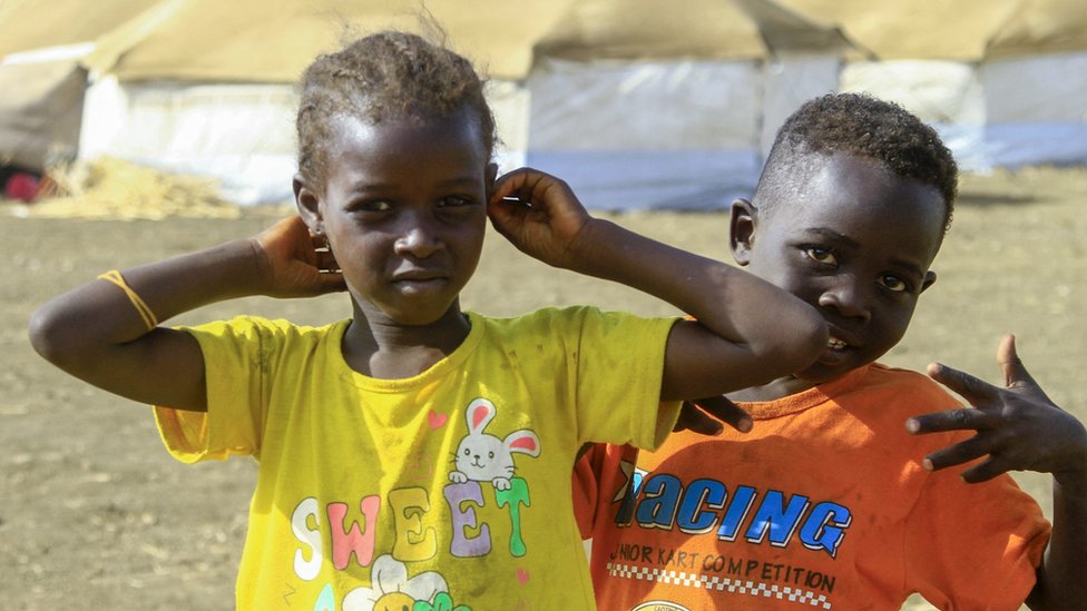 A picture taken on 20 March, 2024, shows children who fled Khartoum and Jazira states playing near tents at a camp for the internally displaced in southern Gadaref state in Sudan.