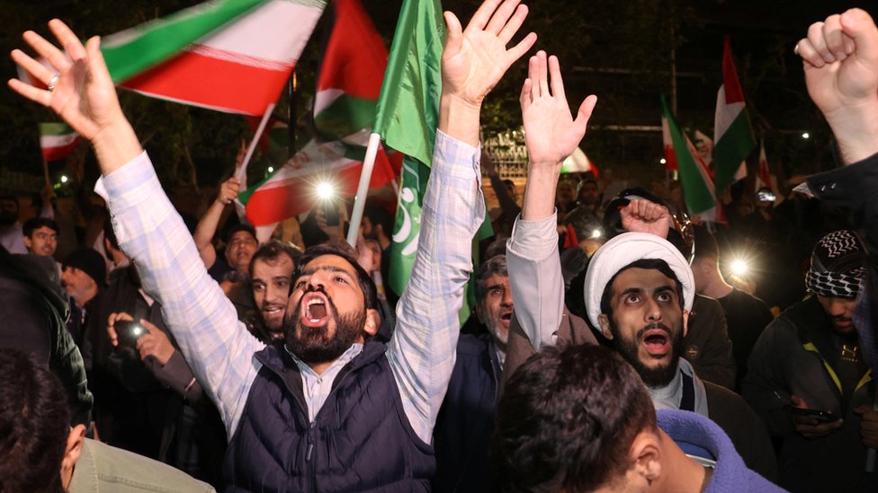 Iranian protesters hold up flags in Tehran