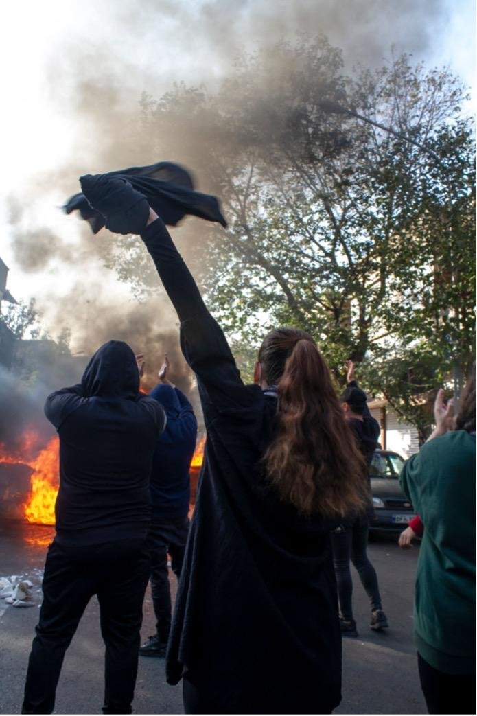 Napad Irana na Izrael: Kakvo je sada raspoloženje u iranskom narodu 4 A woman without wearing a hijab beside other protesters gathers around burning dumpsters during a protest. The nationwide protests started after the death of Mahsa Amini, a 22-year-old girl who died under the custody of the Islamic Republic's Morality Police on September 16th, 2022 in Tehran, Iran.